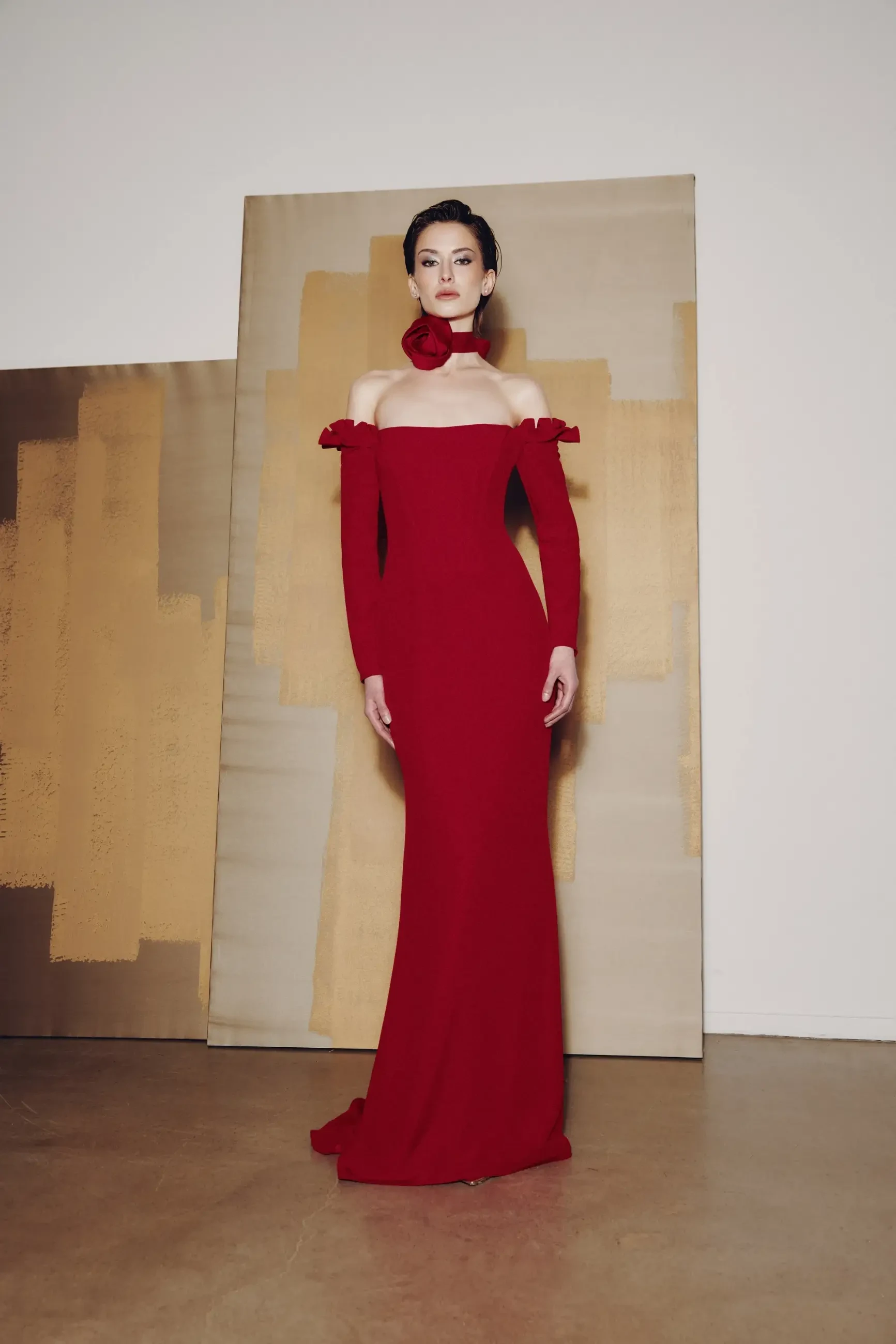 model is wearing an off the shoulder red mother of the bride dress