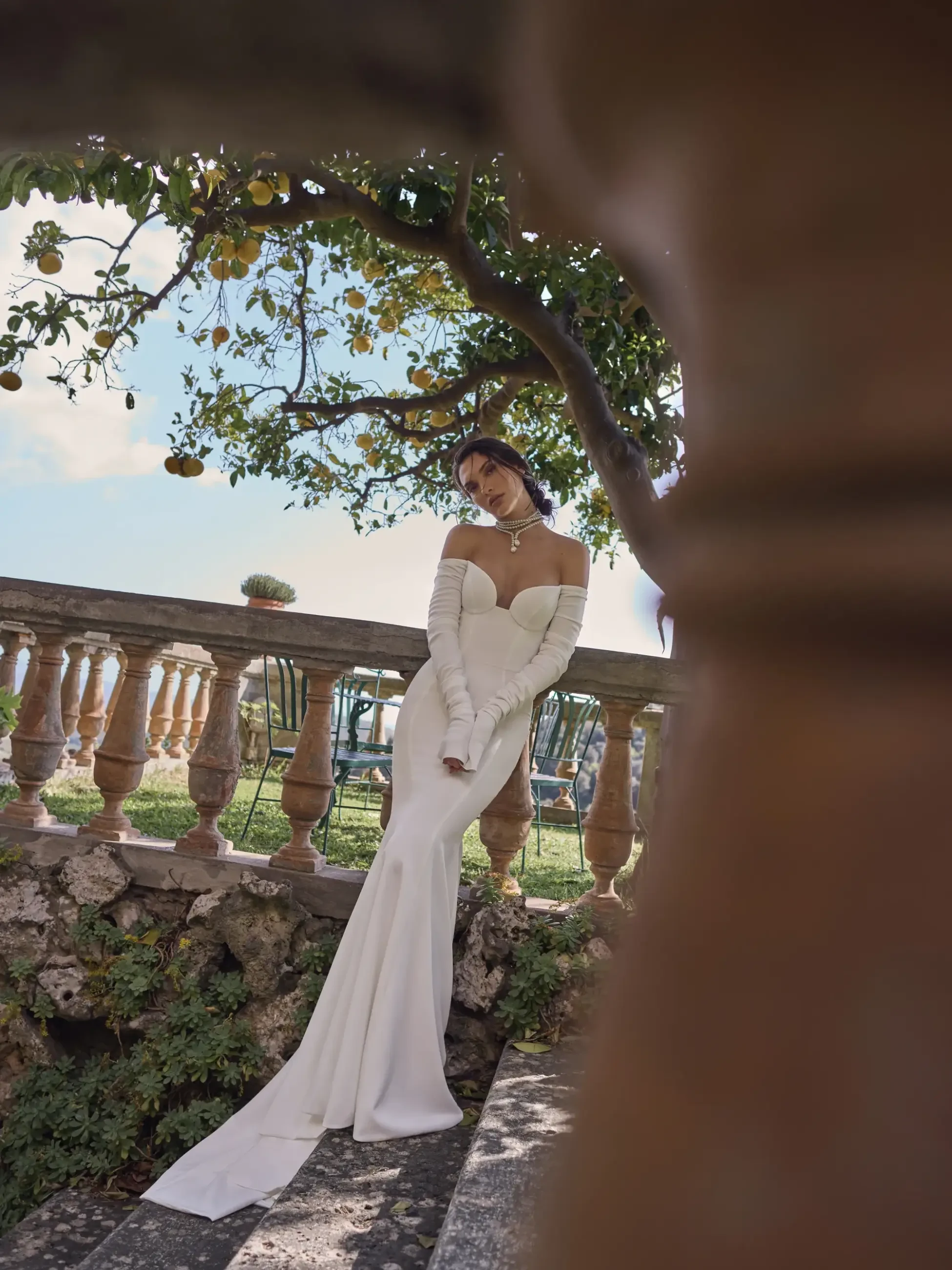 model is wearing a long sleeve off the shoulder wedding dress