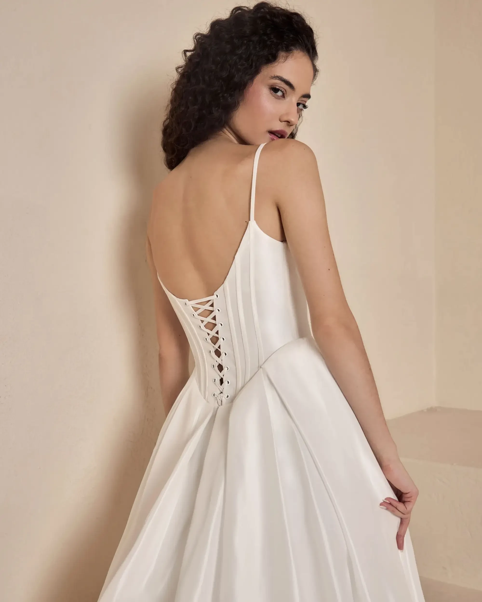 model is wearing a sleeveless corseted wedding dress