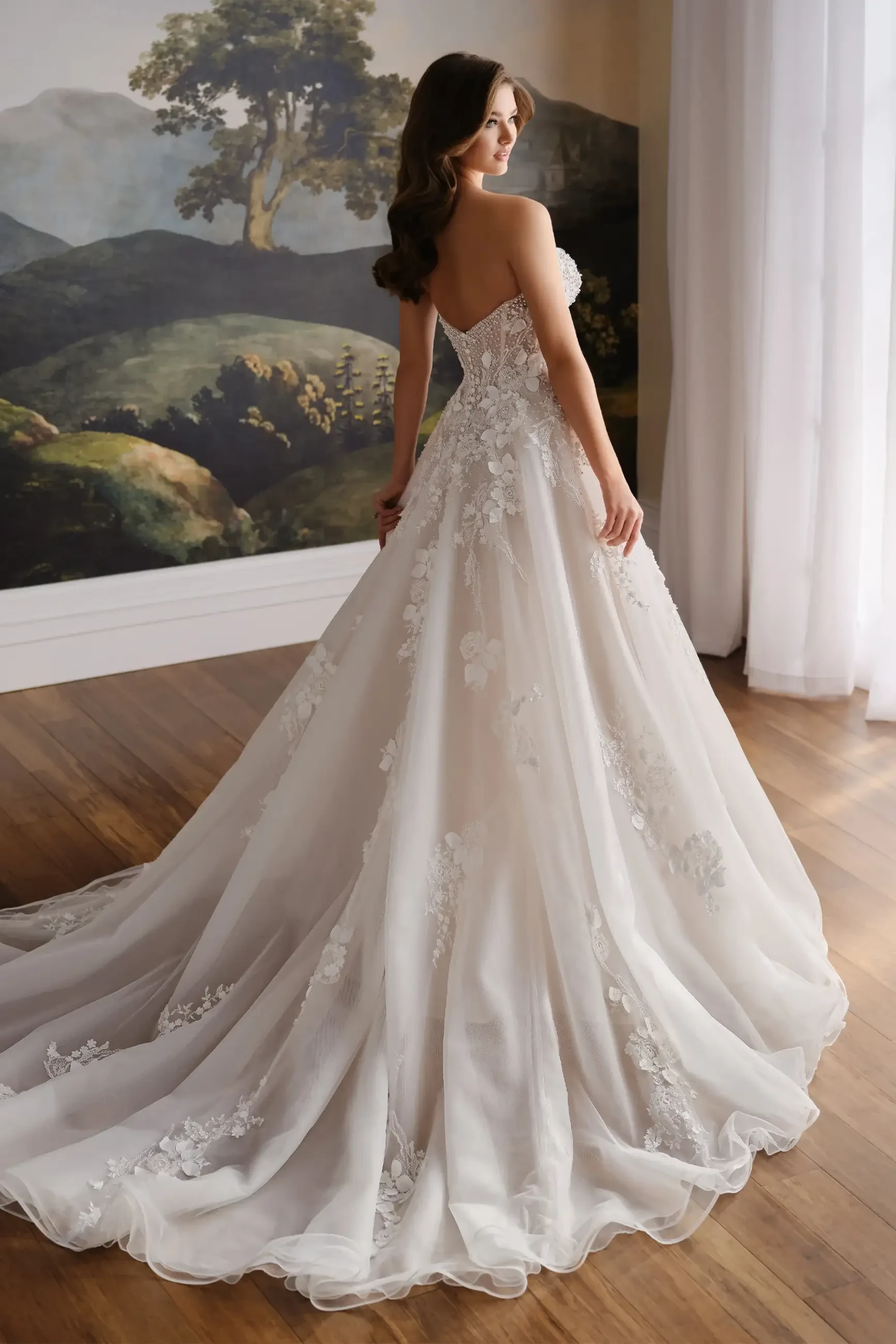 model is wearing a strapless a-line bridal gown with 3d floral appliques