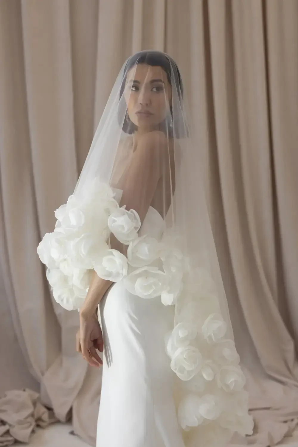 model is wearing an elaborate bridal veil by justin alexander